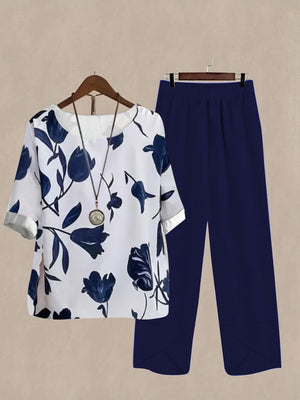 Floral print half sleeve top and navy blue pants set with round neckline and cuffed sleeves.