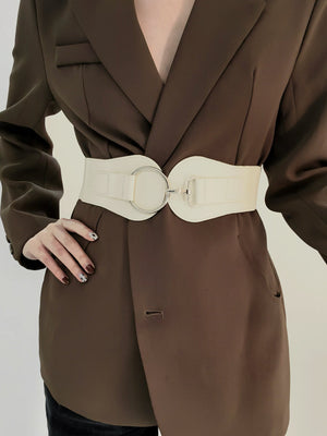 White cincher belt with silver buckle detail, styled over a brown blazer.