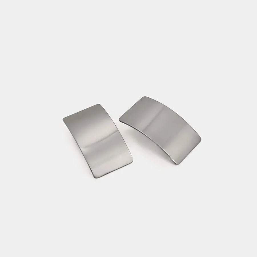 Sculpted silver-tone statement earrings with a bold, curved design.