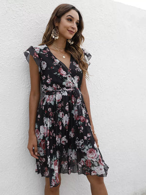 Black floral pleated dress with ruffle sleeves and a tie waist.