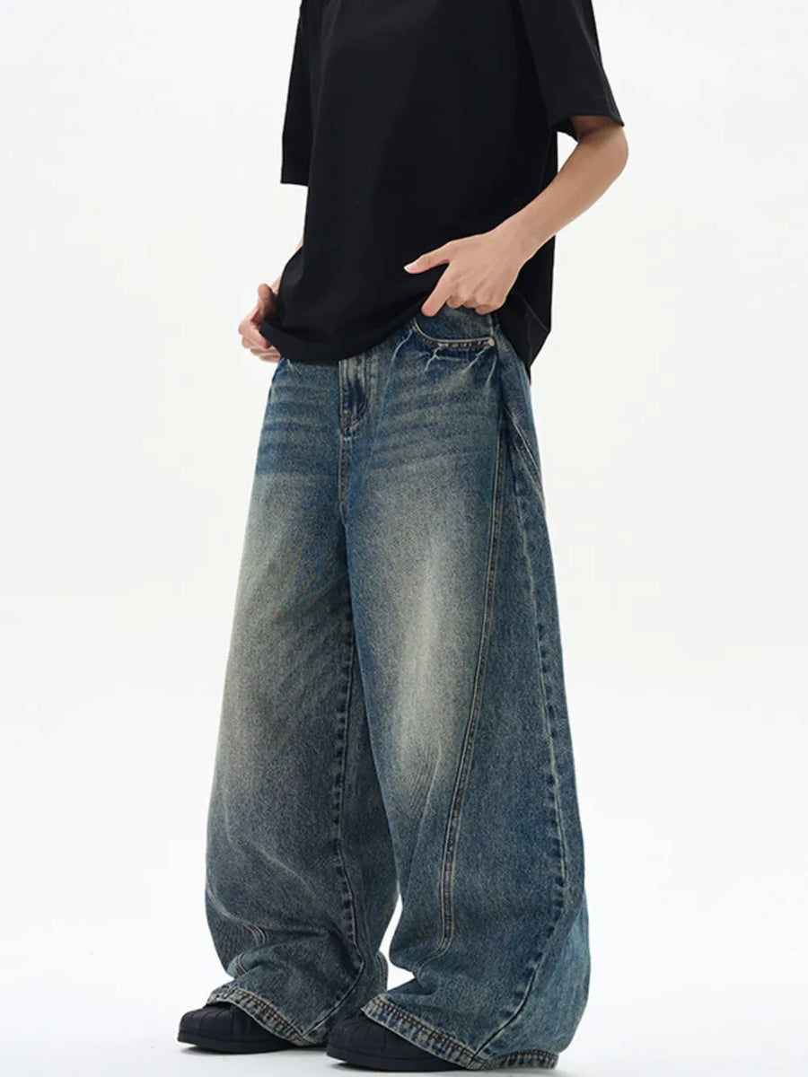 Oversized vintage-finish men's baggy jeans in dark blue denim with distressed details.