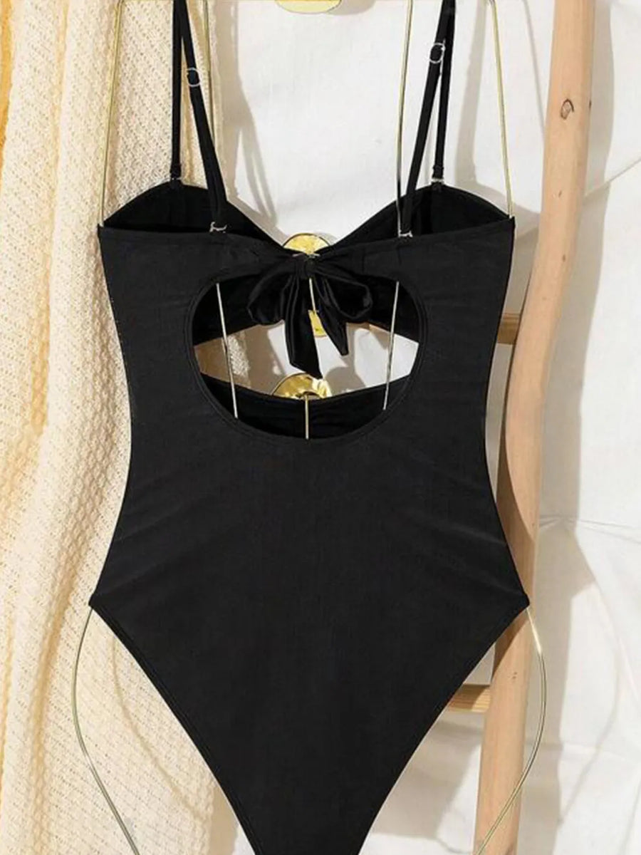 Black one-piece swimsuit with cutout back detail and bow accent
