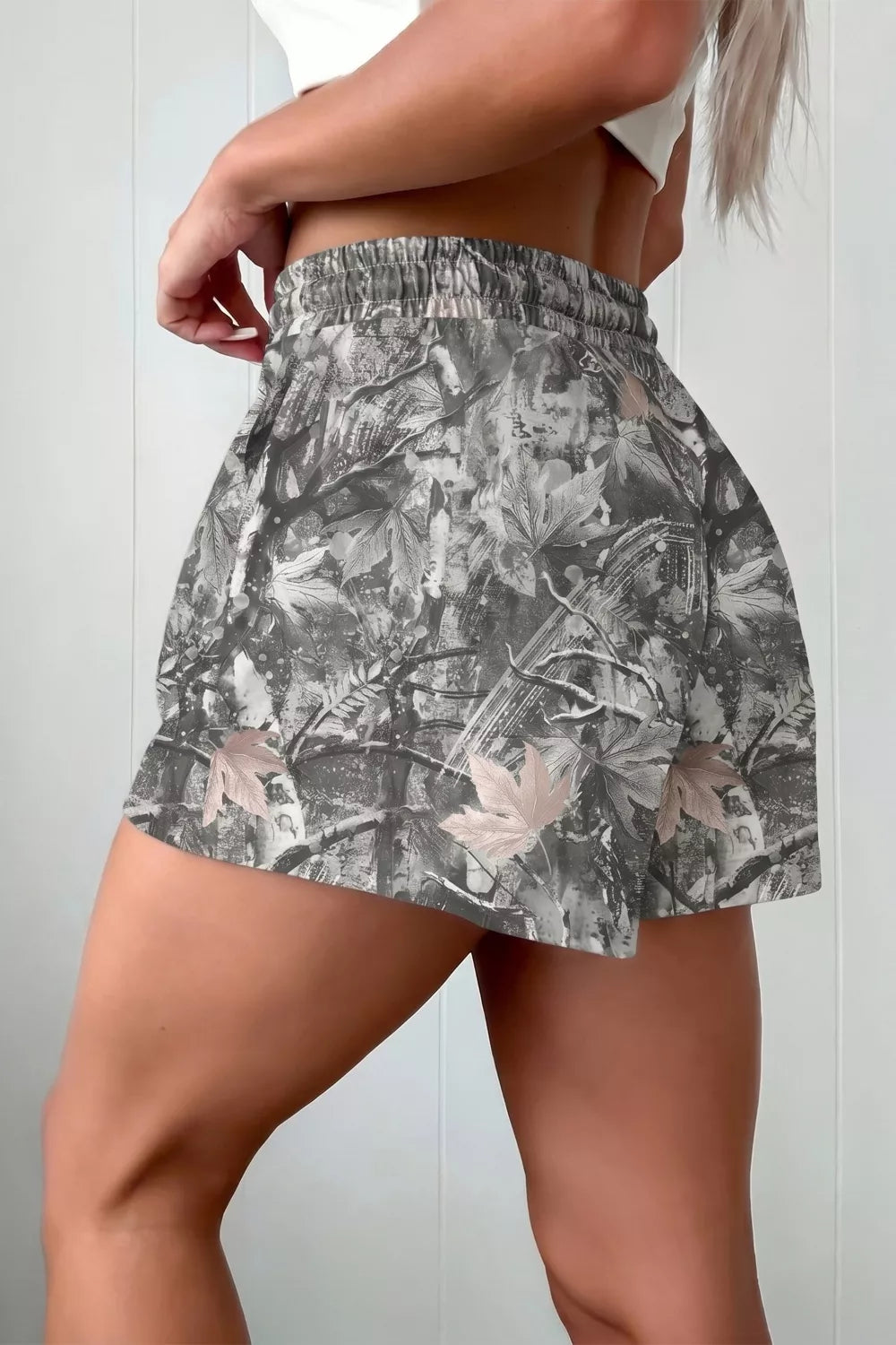 Chino shorts with elastic waist and abstract maple leaf print in grey and beige accents.
