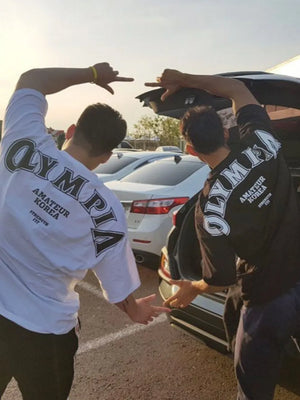 White and black oversized tees with bold Olympia back print and casual fit.