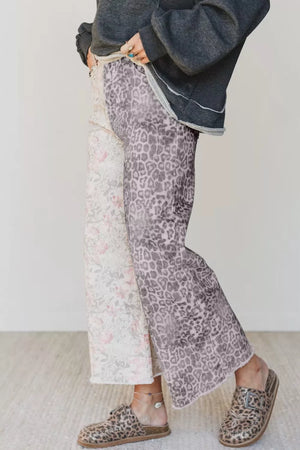 Wide-leg jeans with floral and leopard print panels, cropped length, and raw hem.