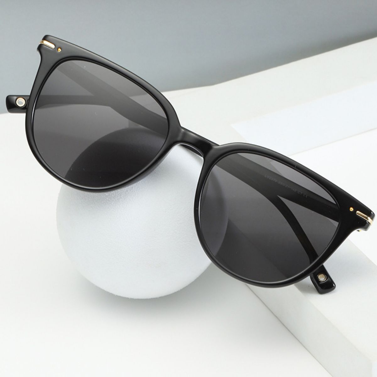 Black cat-eye sunglasses with polycarbonate frame and gold accents
