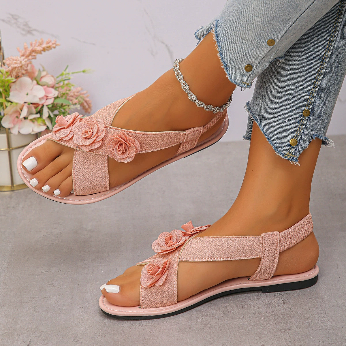 Pink floral embellished comfort slingback sandals with cross straps and elastic heel strap.