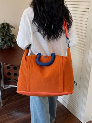 Spacious orange Oxford cloth travel bag with blue handles and orange trim