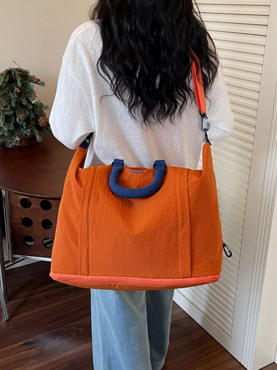 Spacious orange Oxford cloth travel bag with blue handles and orange trim