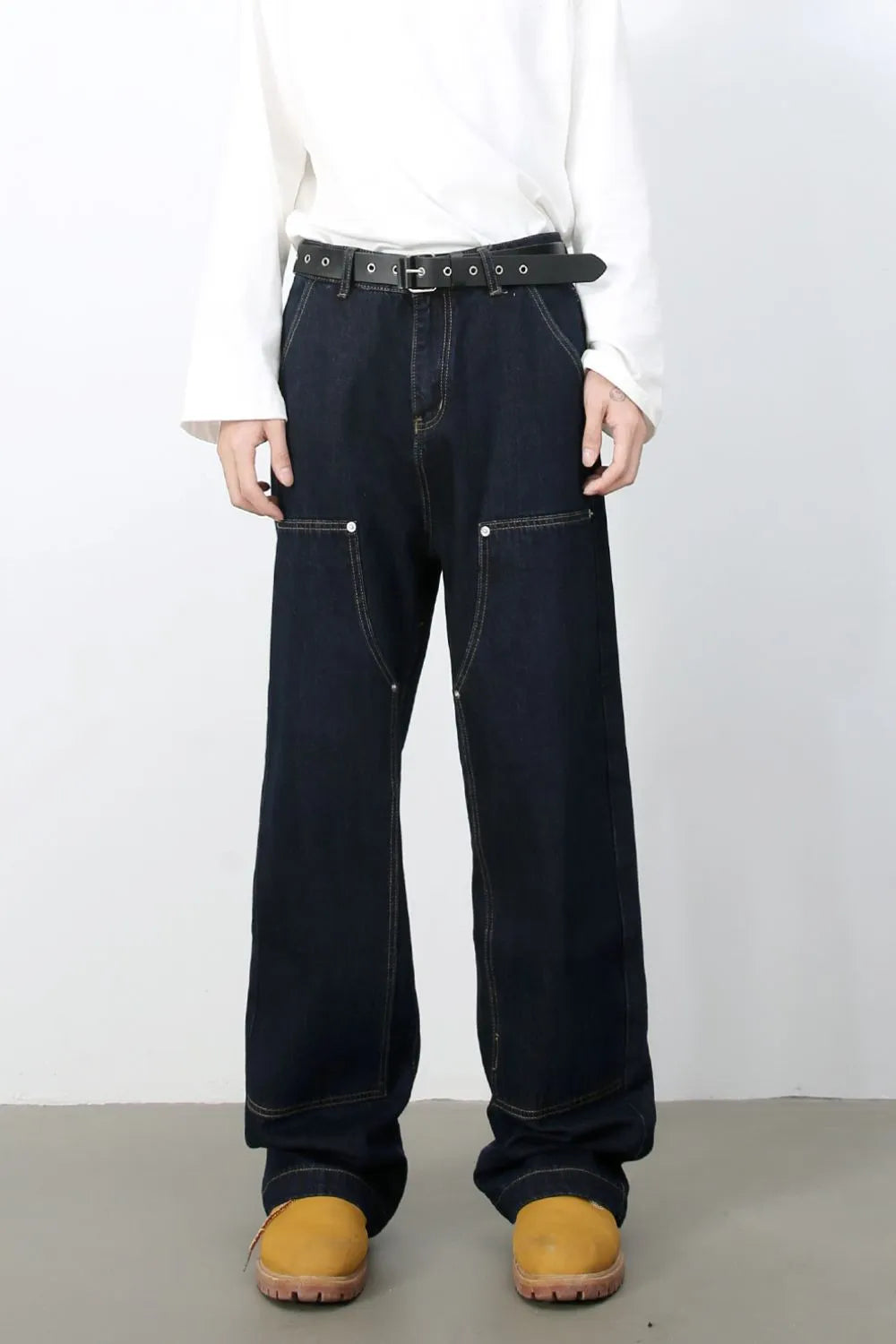 Dark wash carpenter jeans with wide, relaxed fit and contrast stitching.