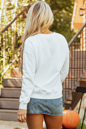 White crewneck sweatshirt with watercolor pumpkin graphic, casual long sleeves.