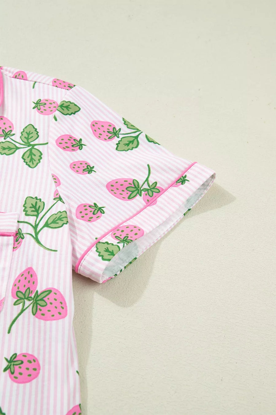 Pink striped pajama set with a whimsical strawberry print and contrast piping.