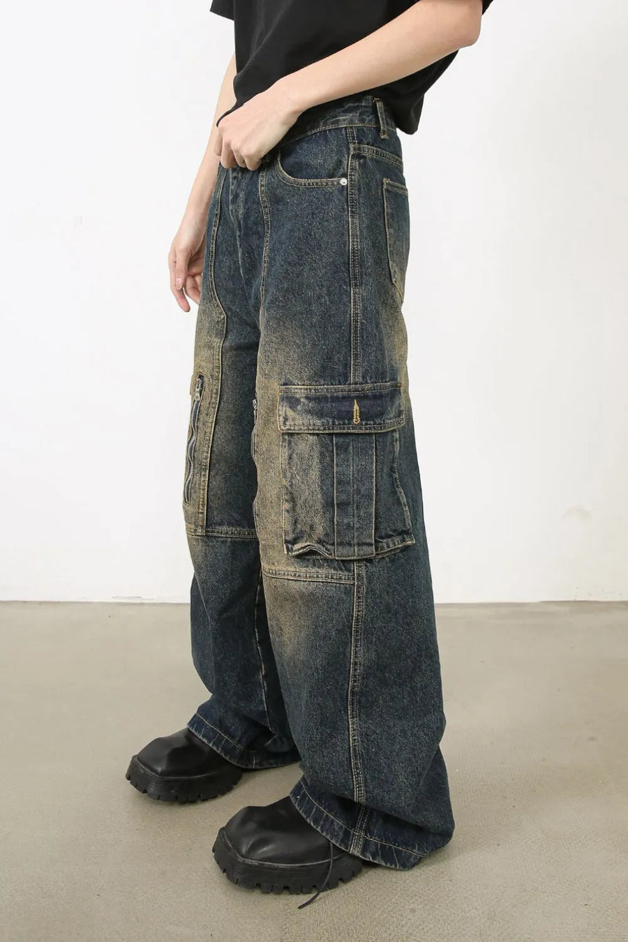 Distressed dark wash wide-leg cargo jeans with zip pockets and flap pockets.