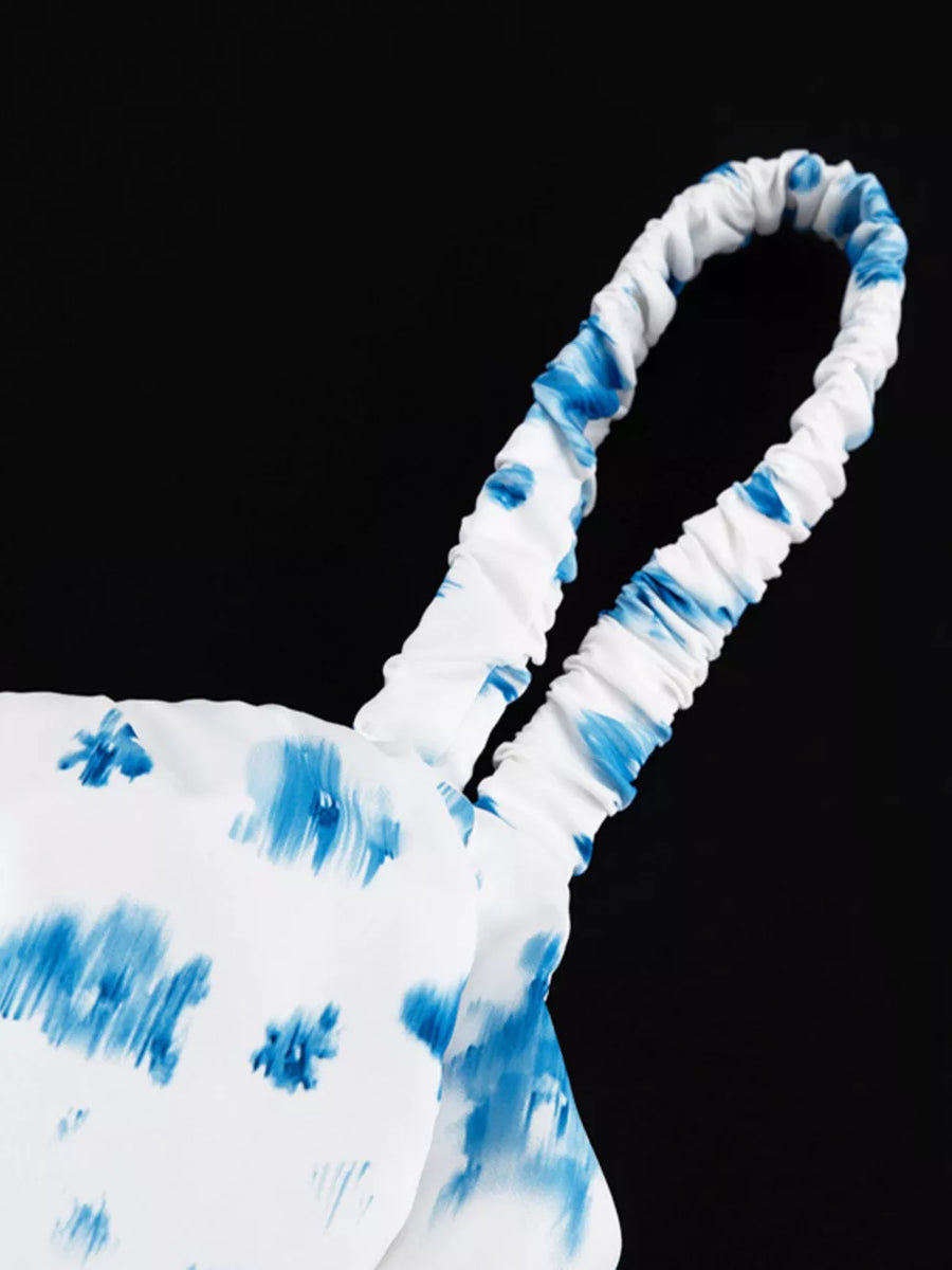 White camisole with blue abstract floral print and ruched spaghetti straps.