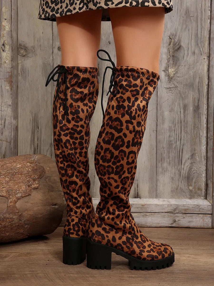 Leopard print over-the-knee boots with back lacing and lug sole.