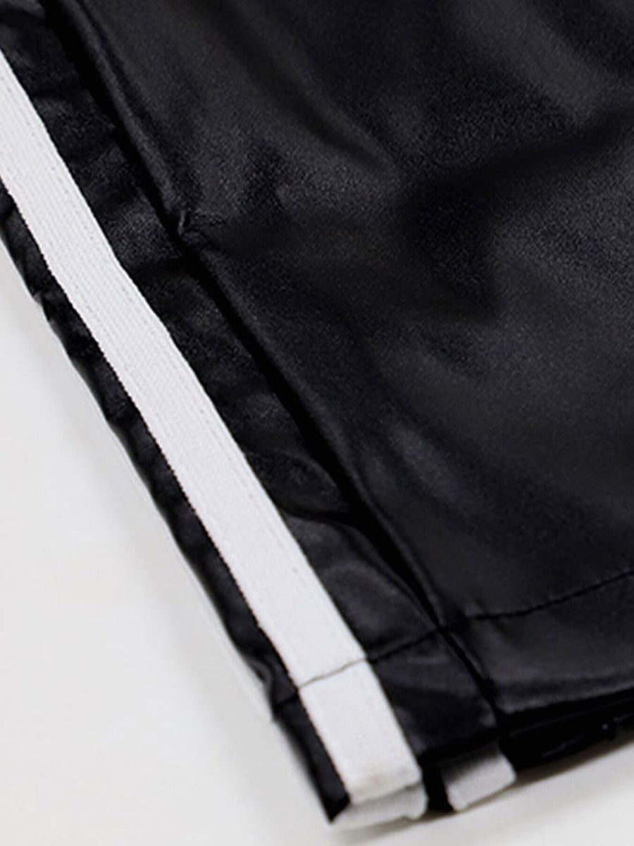 Black faux leather wide leg track pants with white side stripes and elastic waistband.