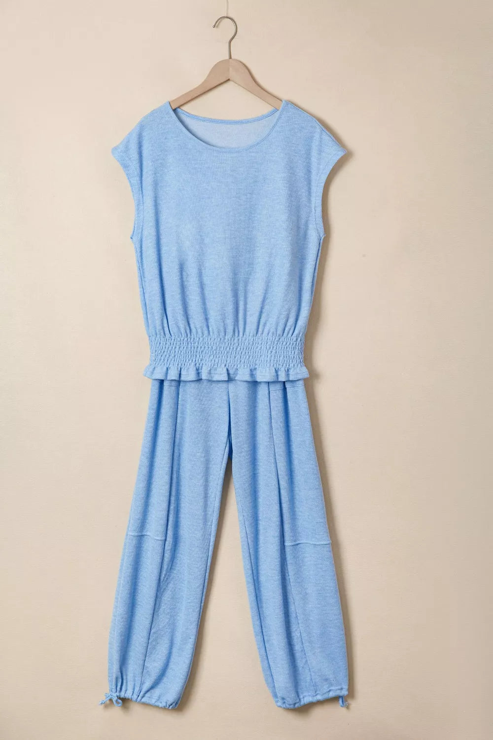 Light blue knit cap sleeve top with smocked waist and jogger pants with drawstring ankles.