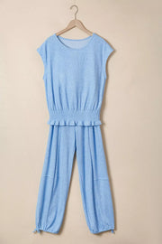 Light blue knit cap sleeve top with smocked waist and jogger pants with drawstring ankles.