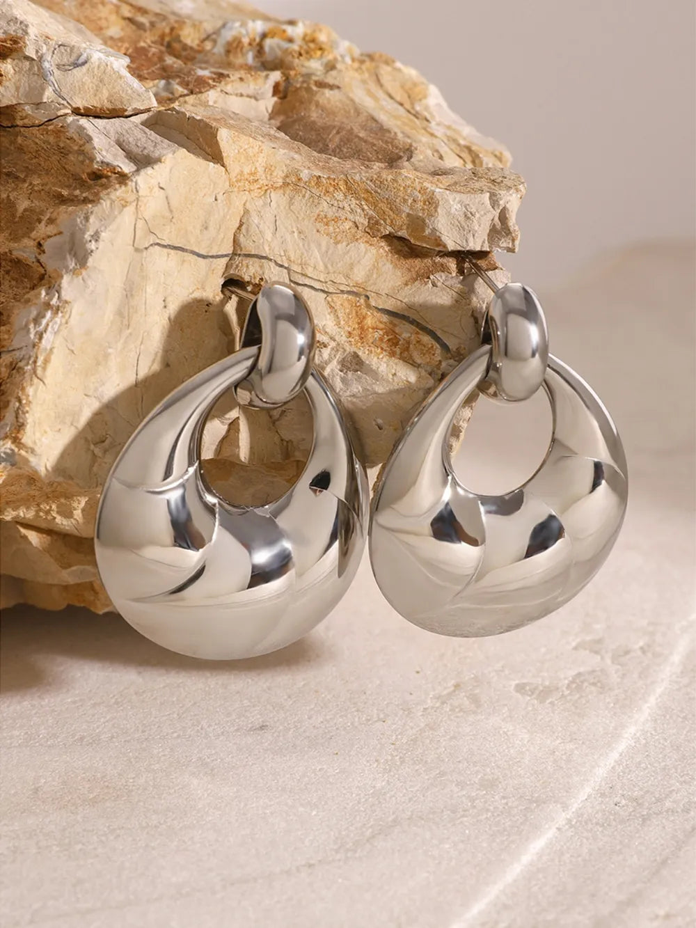 Sculpted silver statement earrings with a chic, boho design.