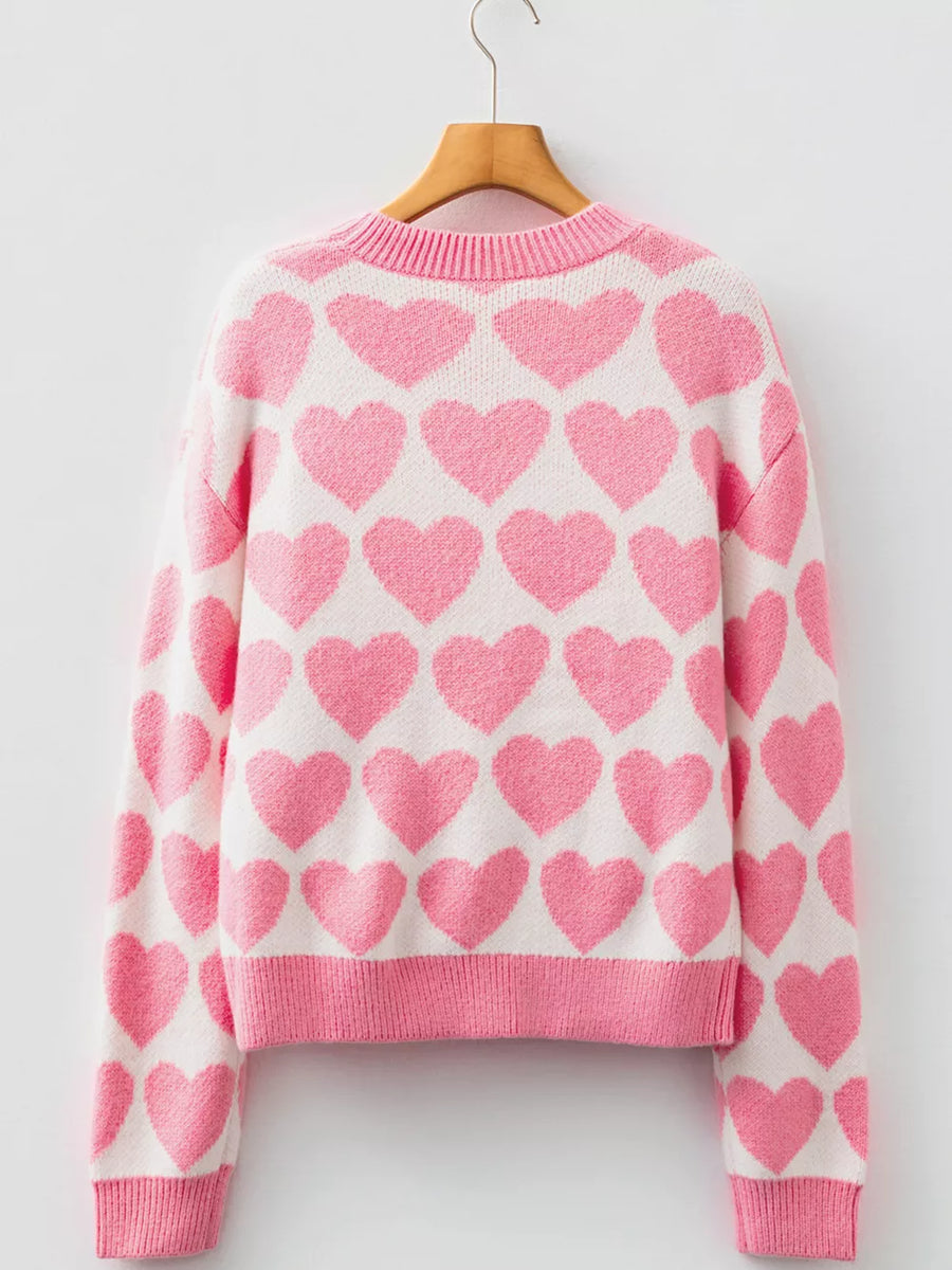 Charming heart pattern knit sweater in blush pink acrylic with crew neck and ribbed trim.