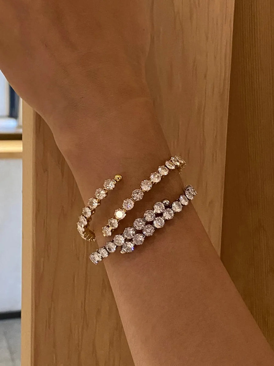 Gold and silver double row pavé bangles with clear stones on a wrist