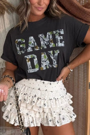 Camo print GAME DAY t-shirt with rolled sleeves, cotton blend, on a woman wearing a ruffled white skirt.