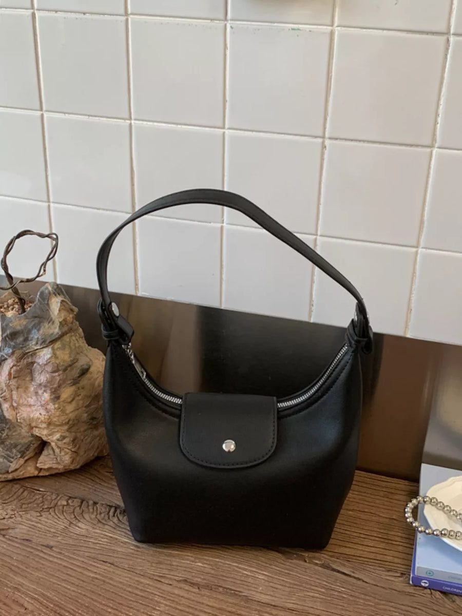 Black mini crescent hobo bag with a flap closure and silver snap.
