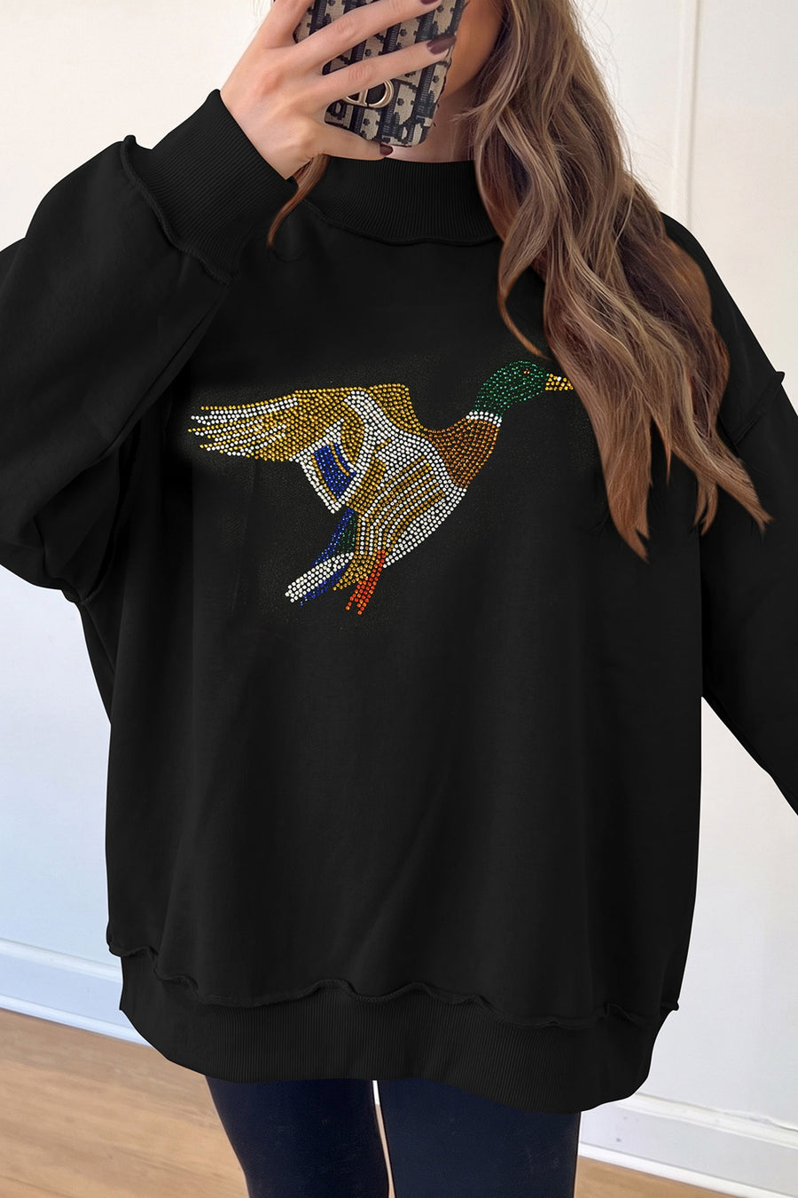 Black sweatshirt featuring rhinestone embellishment and graphic print