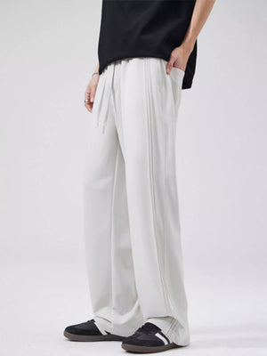 Relaxed fit drawstring casual pants in light gray with vertical seam detail and pockets.