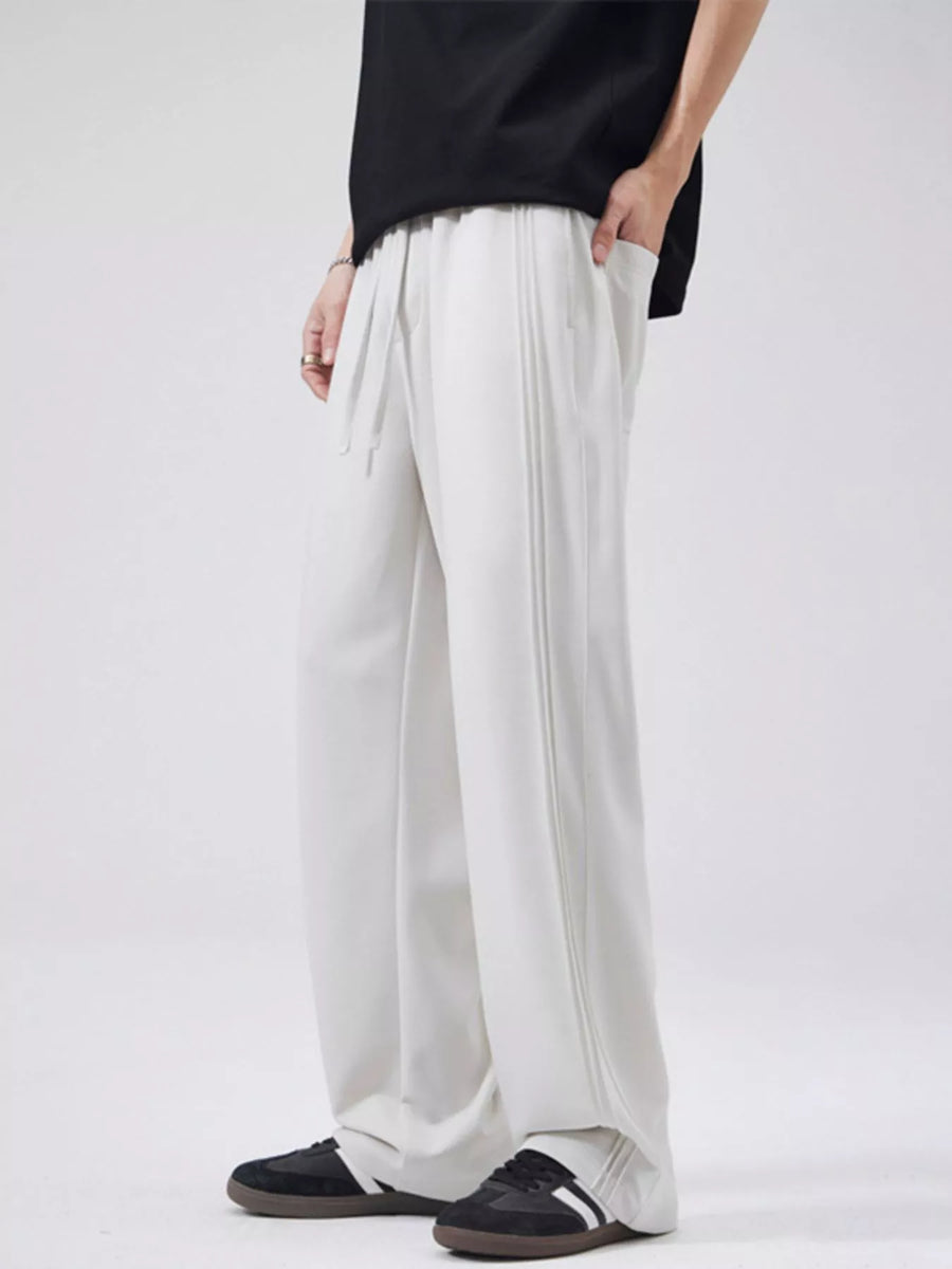 Relaxed fit drawstring casual pants in light gray with vertical seam detail and pockets.