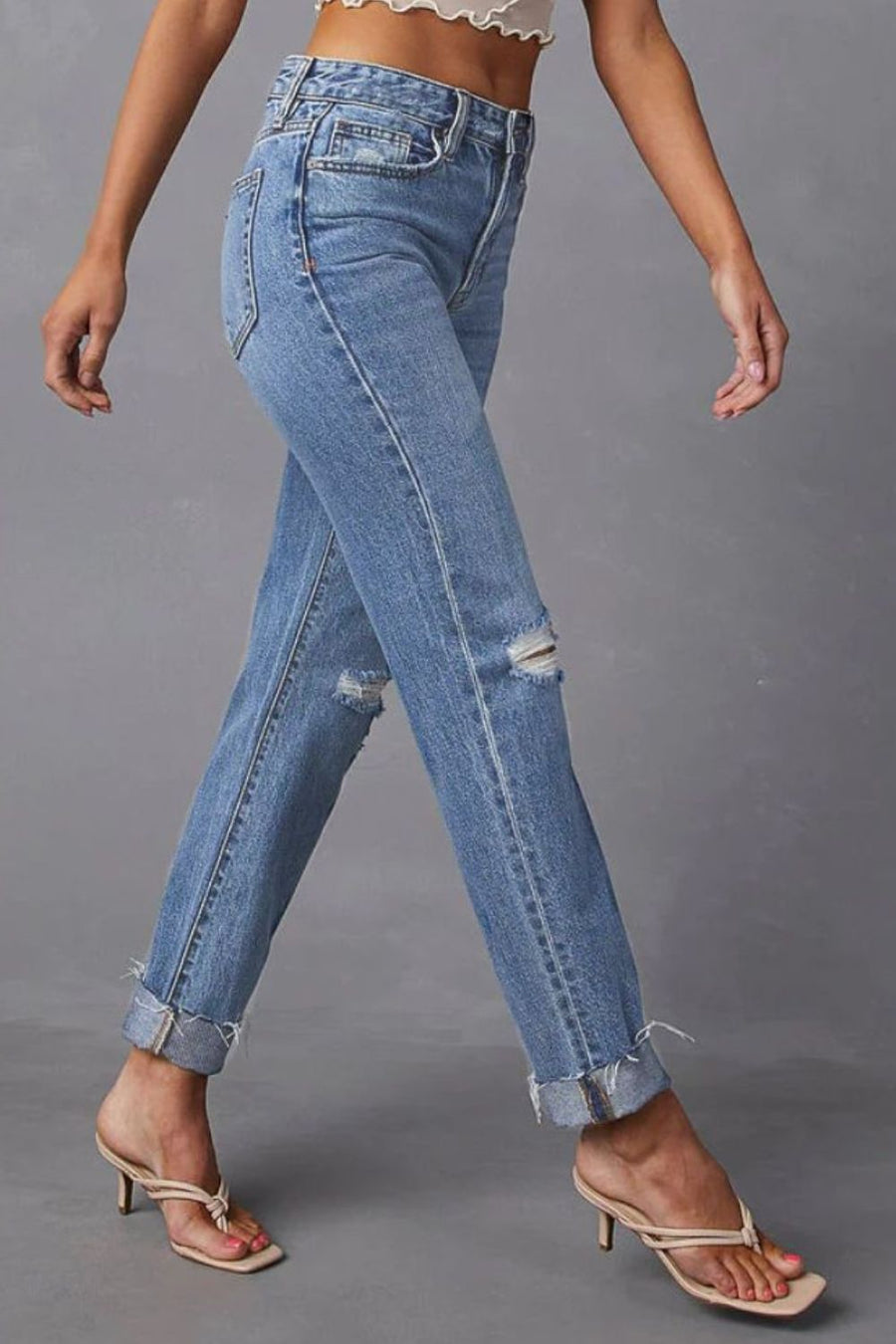Medium wash distressed straight leg jeans with ripped knees and cuffed hems.