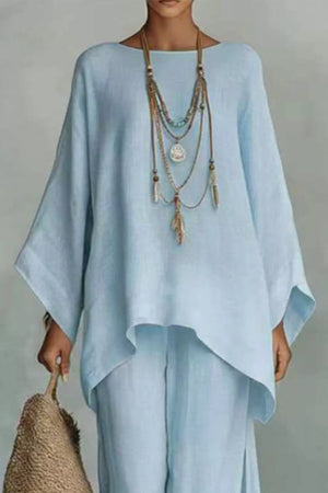 Light blue polyester two-piece set with flowing top and wide sleeves, layered necklace.