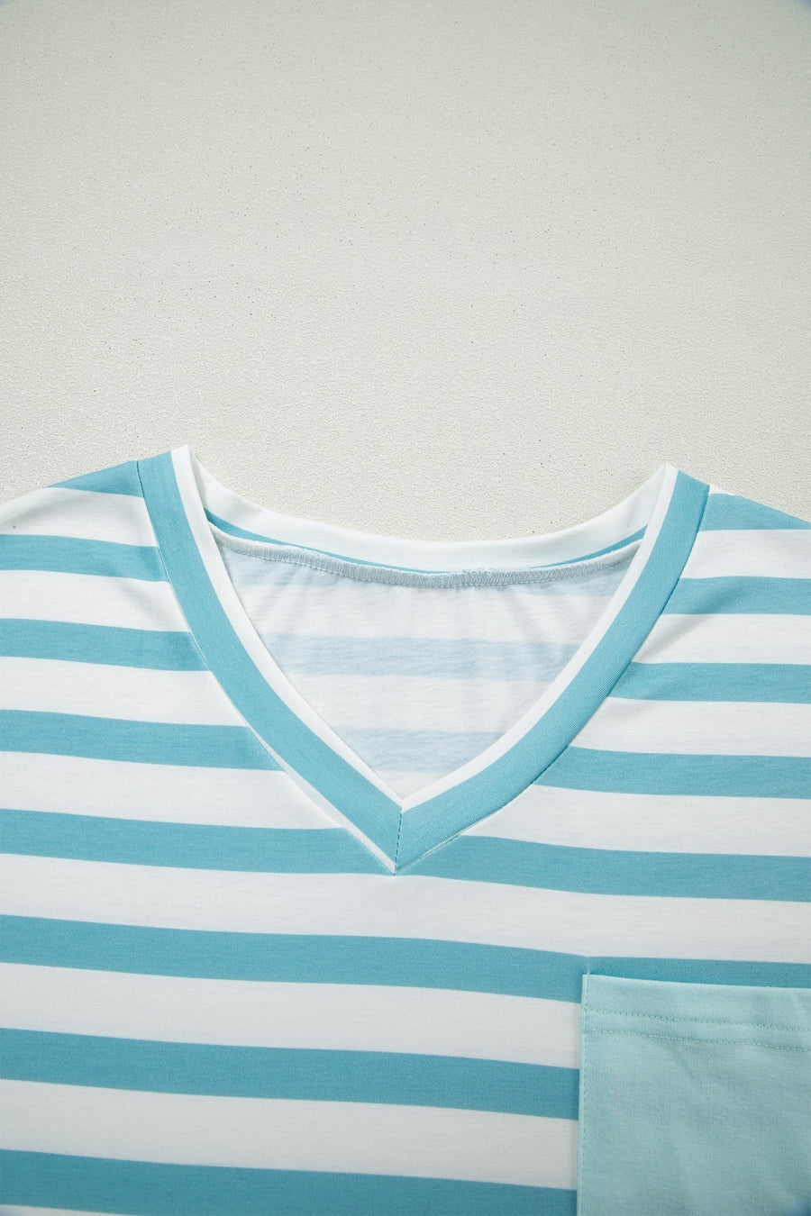 Striped V-neck t-shirt in teal and white with a chest pocket.