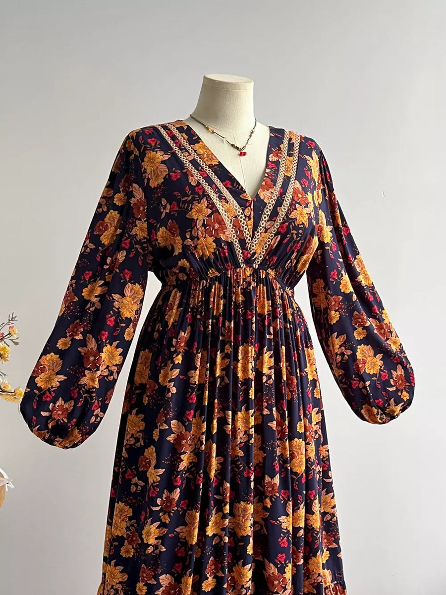 Maxi dress with V-neck, long sleeves, and floral print in navy with yellow and red flowers.