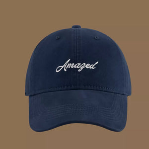Navy blue cotton baseball cap with white embroidered Amazed text.