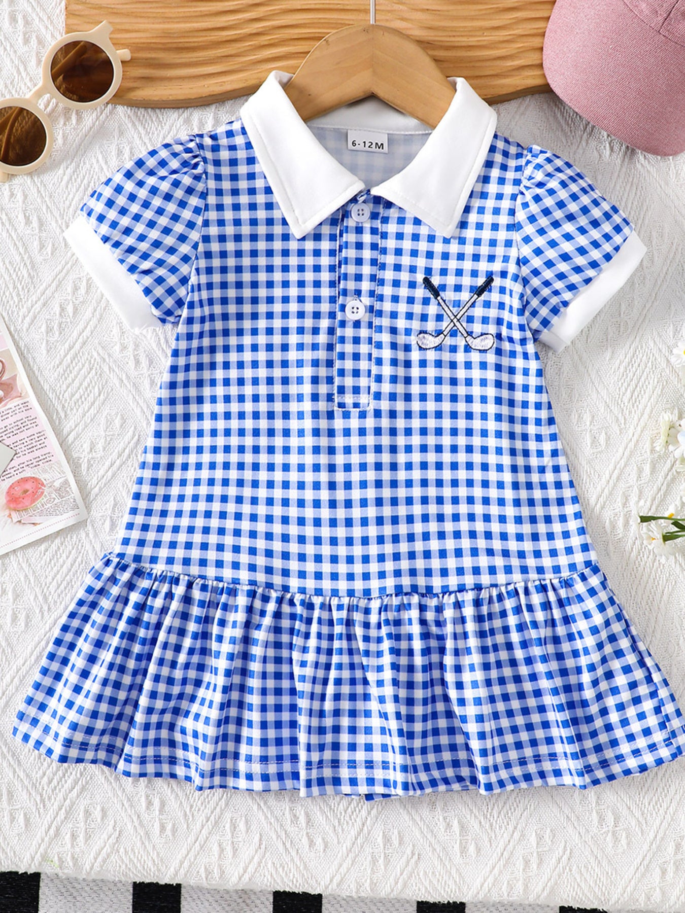 Baby blue gingham polo dress with white collar, short sleeves, and embroidered golf clubs.