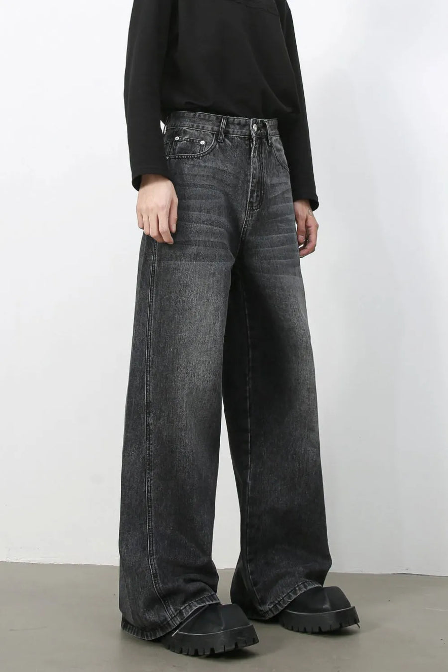 Dark wash denim trousers with exaggerated wide legs and a casual fit.