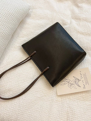 Black PU leather shoulder tote bag with thin straps and minimalist design.