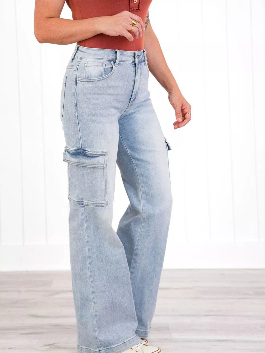 Light wash denim wide-leg cargo jeans with flap pockets and a relaxed fit.