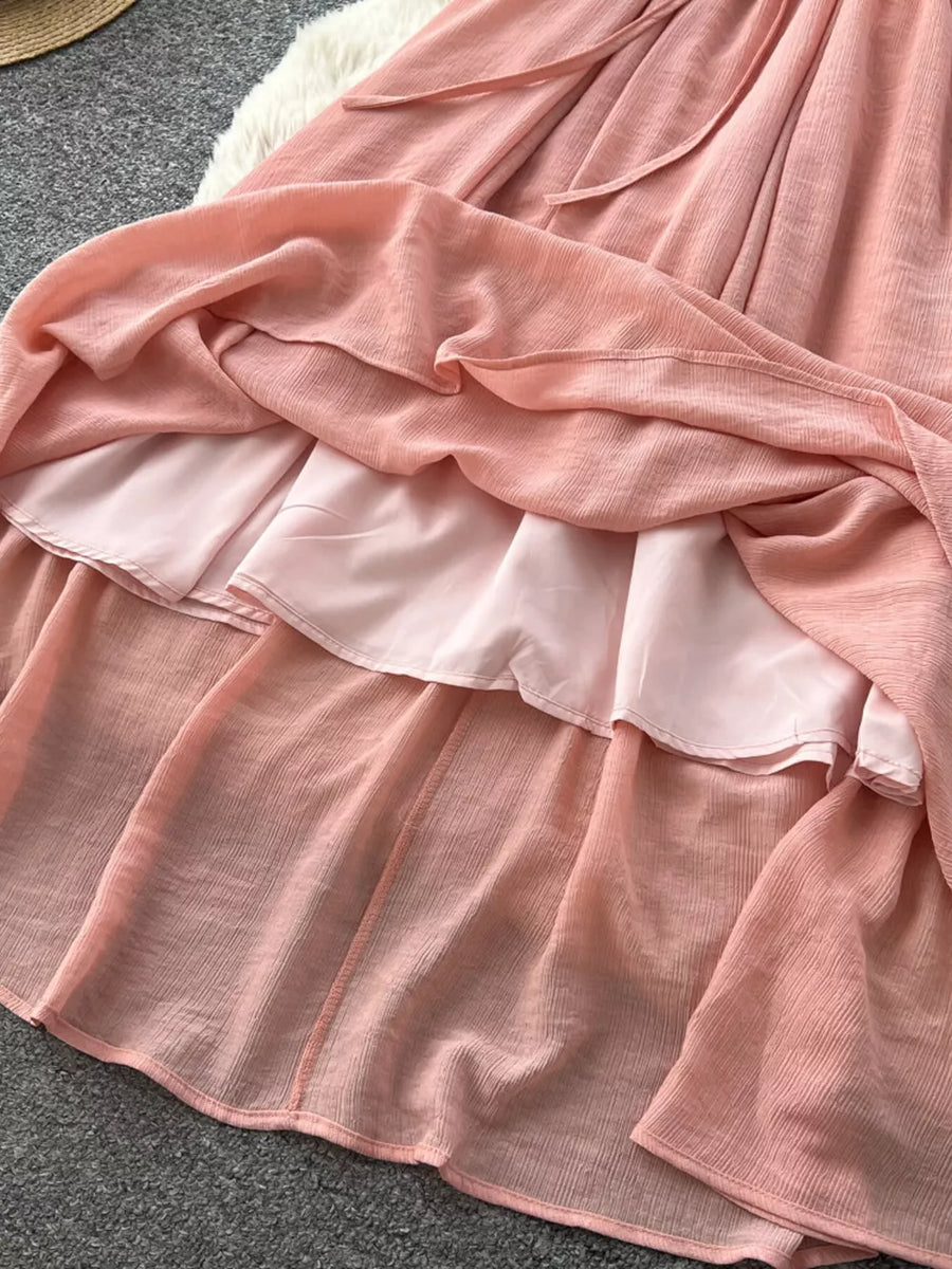 Pink embroidered V-neck bohemian maxi dress with tiered skirt detail.