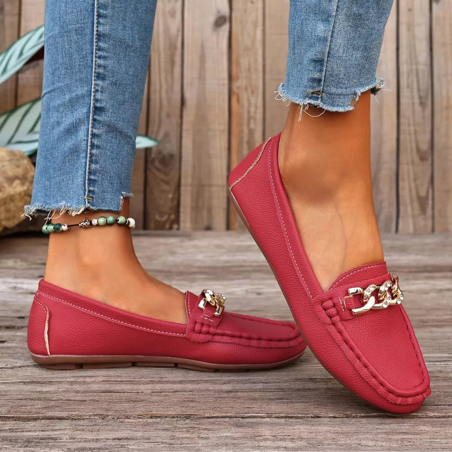 Chic red round-toe loafers with gold chain detail and contrast stitching.