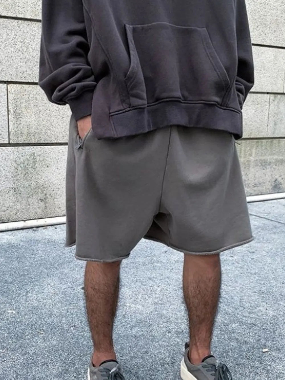 Gray relaxed fit shorts with raw hem detail.