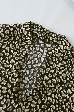 Chic midi dress in black with animal print, featuring balloon sleeves.