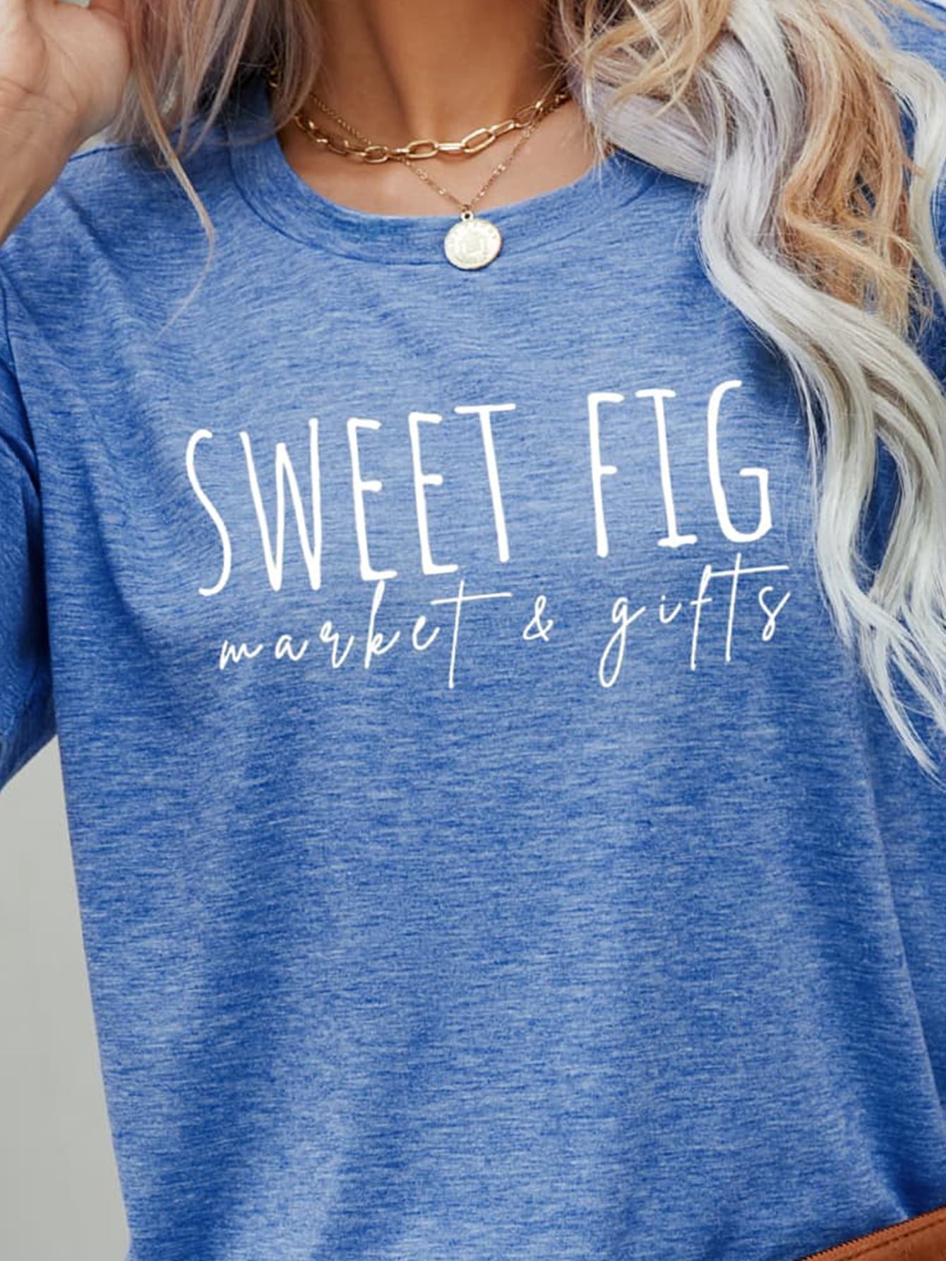 Cobalt blue graphic t-shirt with white "Sweet Fig market & gifts" text.