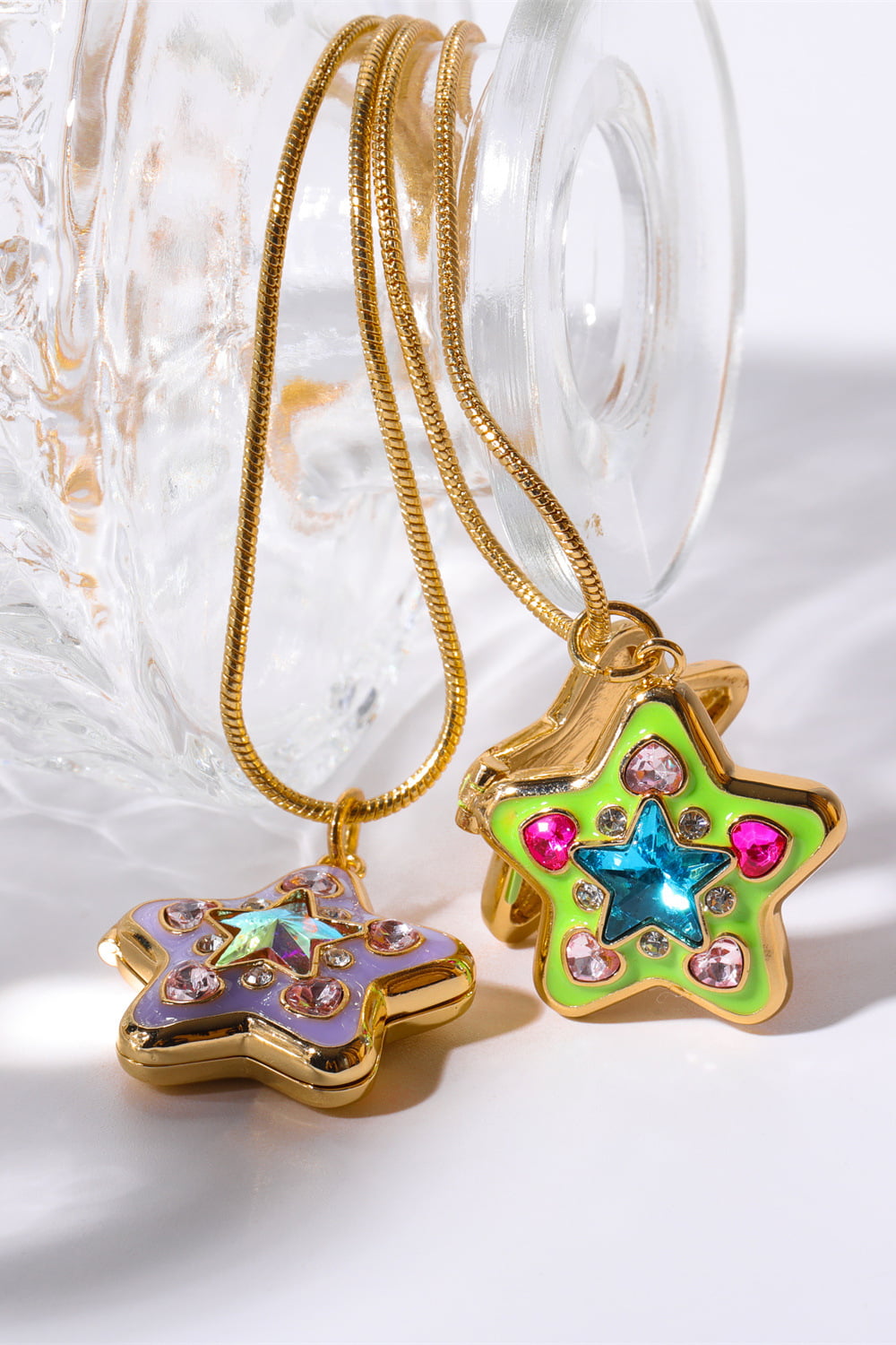 Locket starburst pendant necklaces in lavender and yellow-green with colorful gems and gold chains.