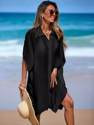 Black button-up cover-up with short sleeves and a collared neckline, worn on the beach.