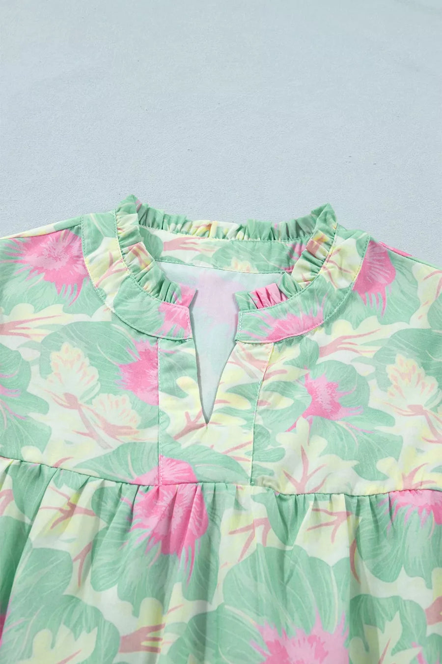 Pastel floral print polyester blouse with ruffled neckline and V-neck detail