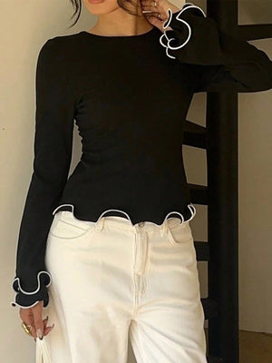 Black crew neck t-shirt with ruffled white trim on sleeves and hem.