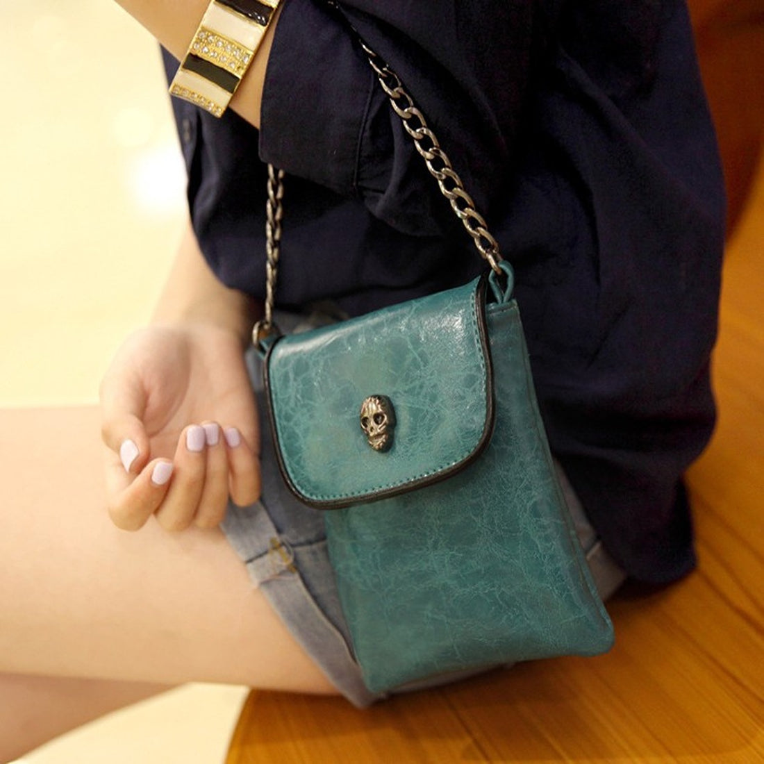 crossbody bag in teal featuring skull embellishment and boxy fit