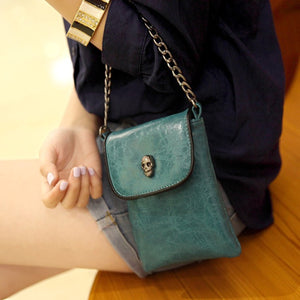 crossbody bag in teal featuring skull embellishment and boxy fit